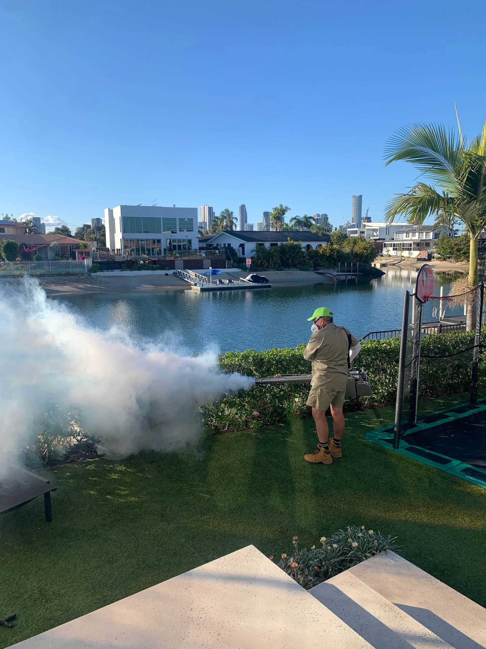 Pest control technician treating backyard